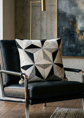 Black and ivory faceted cowhide cushion styled on a black leather armchair