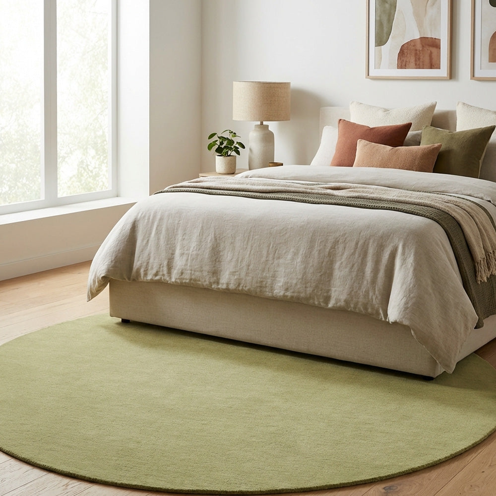 Green round wool rug in bedroom