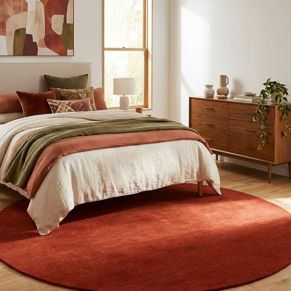 Red round wool rug in bedroom