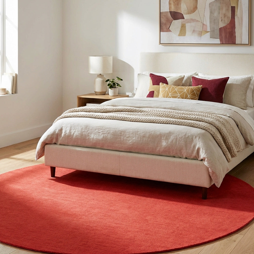 Neon red round wool rug in bedroom