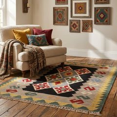 Living room with a beige sofa, colorful pillows, and a patterned kilim rug.