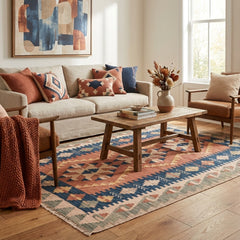 Living room with a beige sofa, wooden coffee table, and colorful kilim rug.