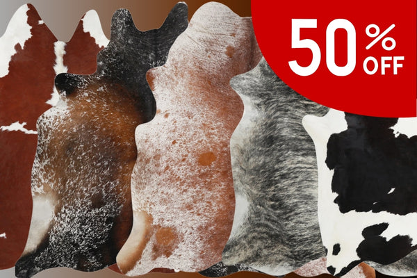 Cowhide rugs in various patterns with a 50% off label.