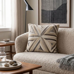 Ivory and grey radiant cowhide patchwork cushion styled on a cream boucle armchair